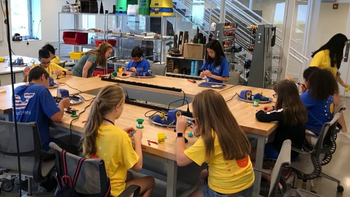 Students building projects together around a makerspace worktable